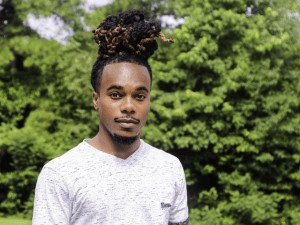 Black man with dreads in white shirt