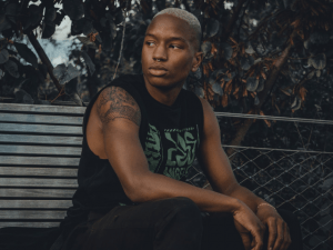 man wearing black shirt sitting on a bench