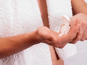 man holding a bottle of cream