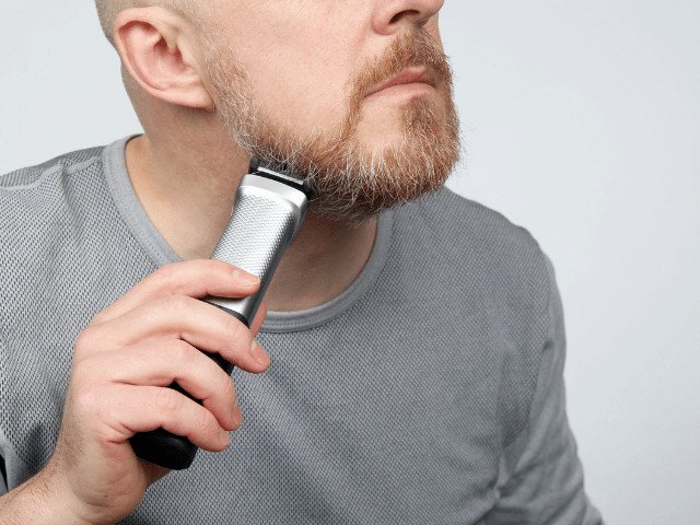 man correcting his beard with a trimmer