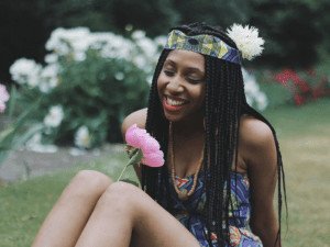woman smiling at a flower