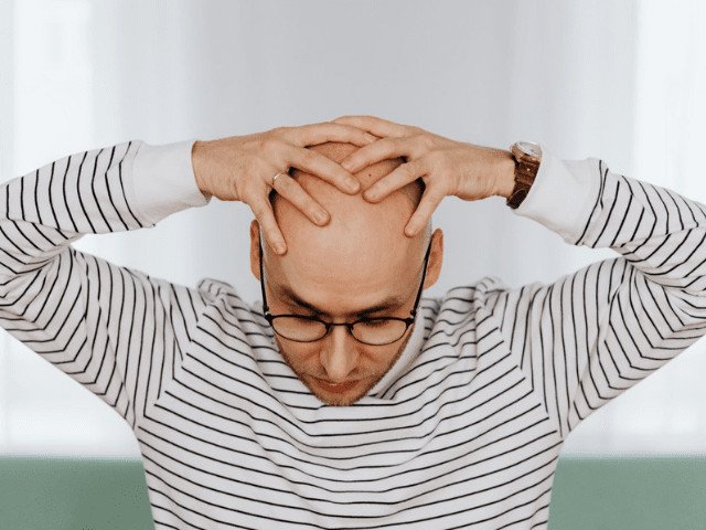 man with hands on head