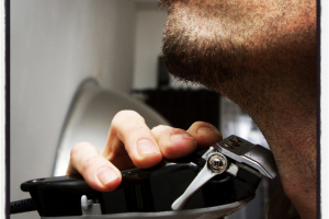 black man trimming hair on neck