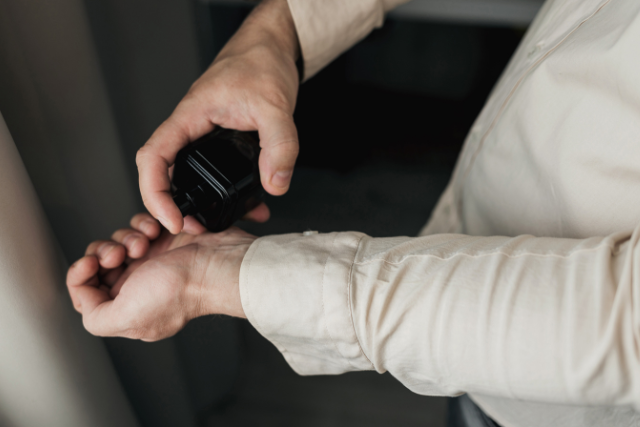 a man spraying cologne on writst